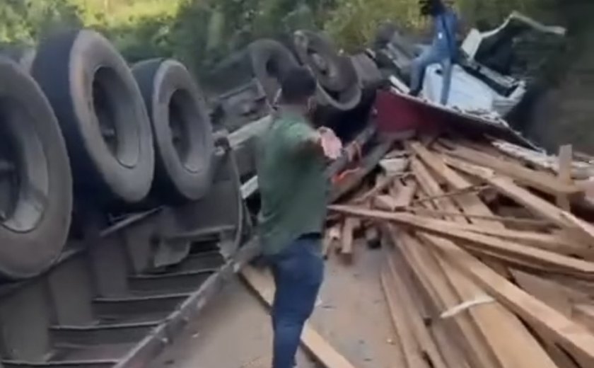 Carreta tomba e derruba carga de madeira na AL-105, em Maceió